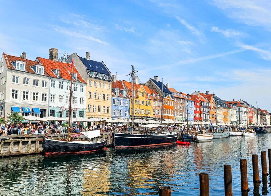 The colourful waterfront houses and historic wooden sailing boats of Nyhavn, Copenhagen, on a sunny day