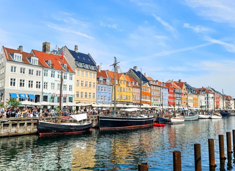 The colourful waterfront houses and historic wooden sailing boats of Nyhavn, Copenhagen, on a sunny day