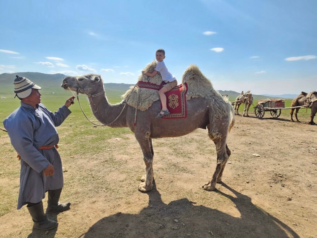 Kids interacting with animals at a Mongolian nomad camp