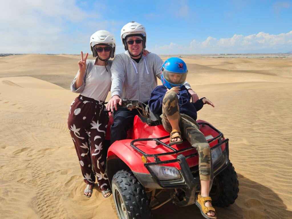 Boy quad biking through the sand dunes near Swakopmund with an adult