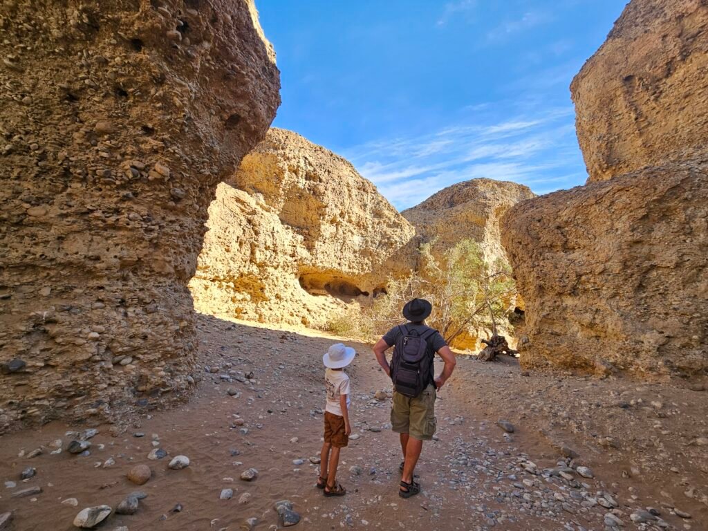 Child walking through the narrow rock walls of Sesriem Canyon