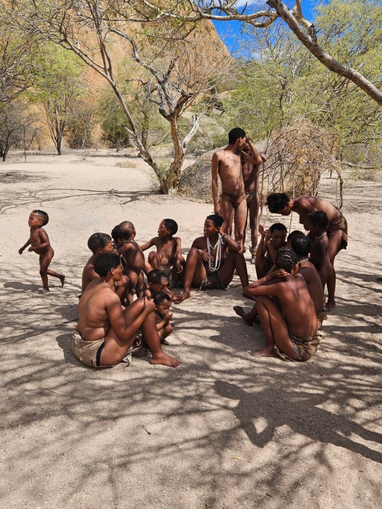San guide sharing traditional knowledge with a visiting family in Namibia