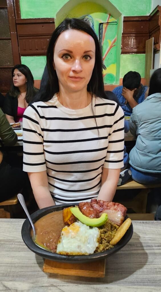 Woman about to eat a bandeja paisa, Colombia's traditional mixed platter, in a Bogotá restaurant