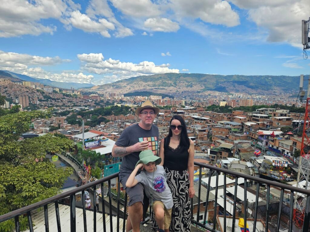 Family posing on a Comuna 13 viewpoint overlooking Medellín