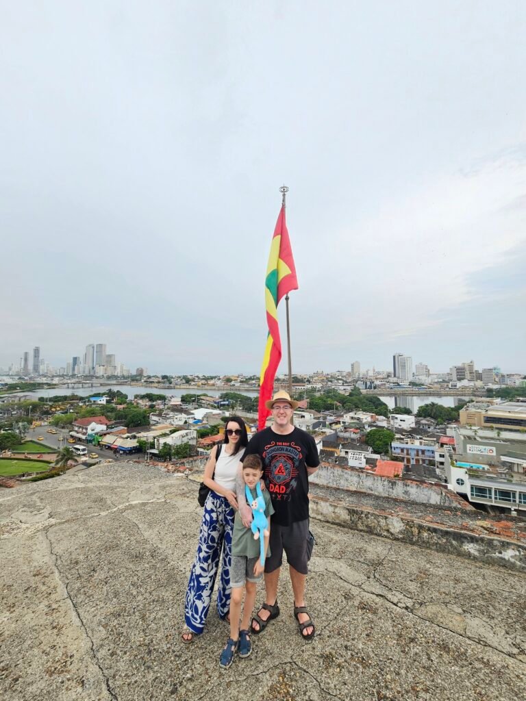 Family standing on the historic Cartagena city walls beside a flag