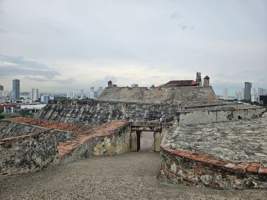Stone ramparts of the Cartagena city walls with the modern skyline behind
