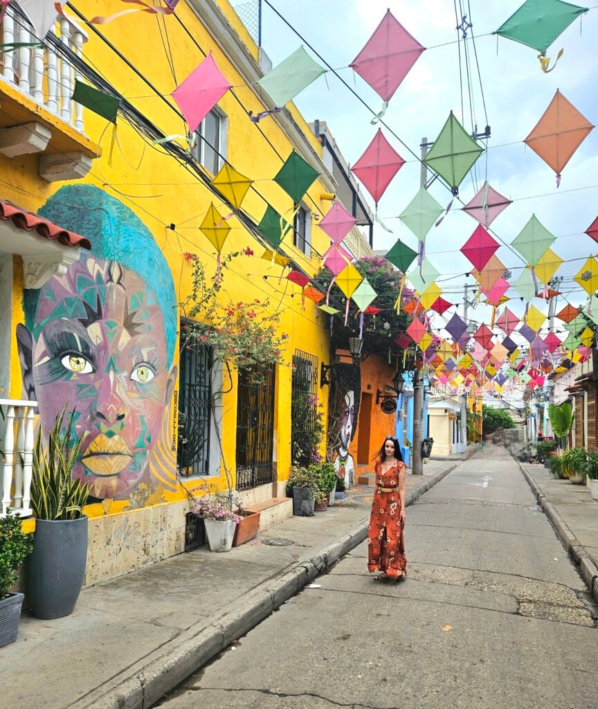 Woman walking beneath hanging kite decorations in Getsemaní, Cartagena