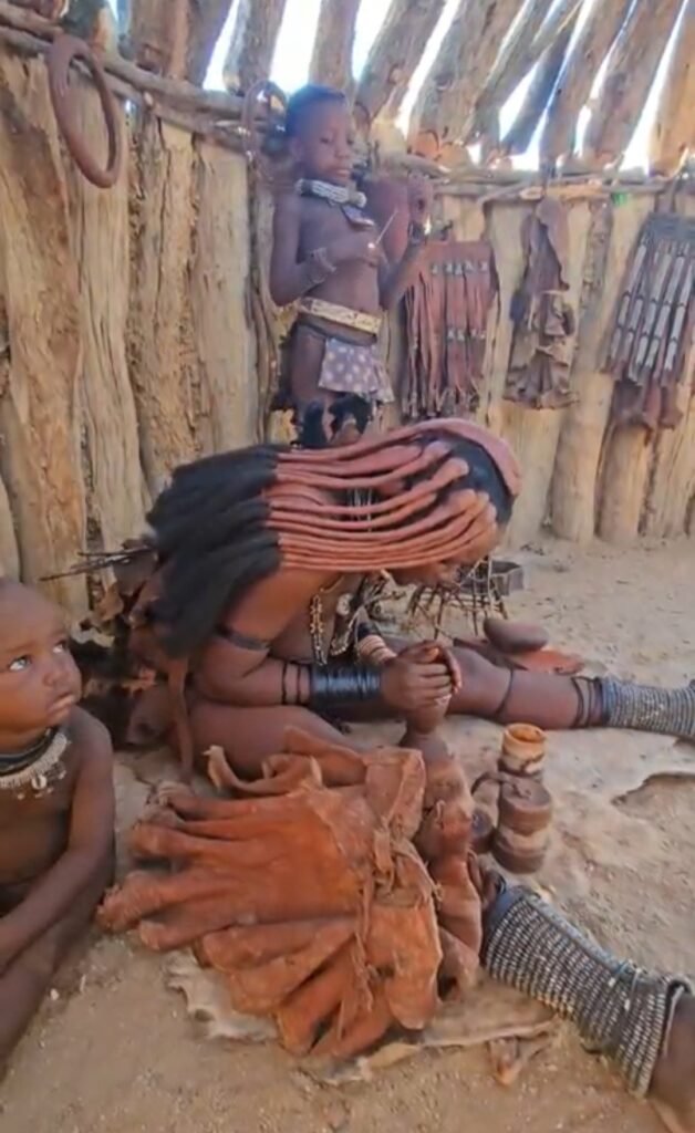 Boy learning about Himba culture and traditions during a village visit