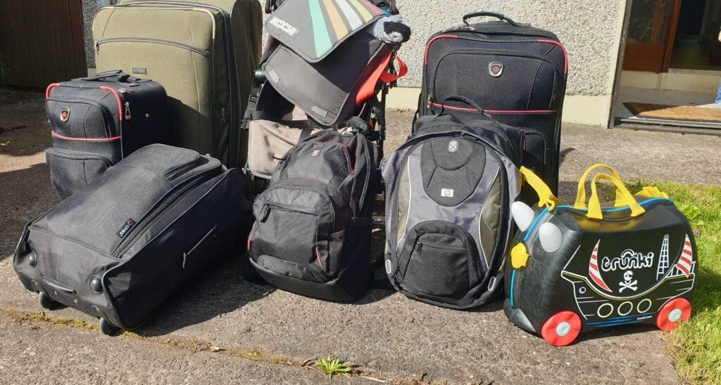Two suitcases and backpacks packed for long-term family travel in 2020