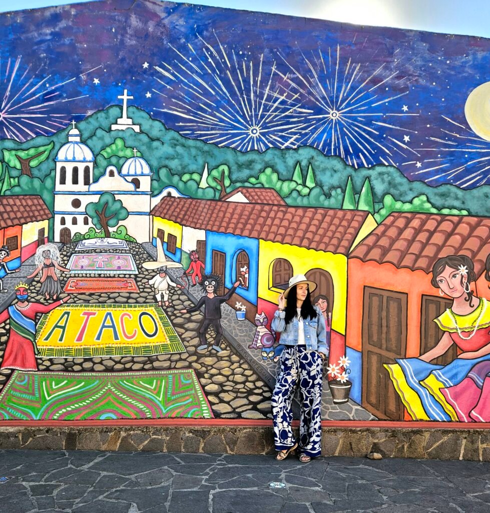 Woman in front of a colourful mural in Concepción de Ataco, El Salvador