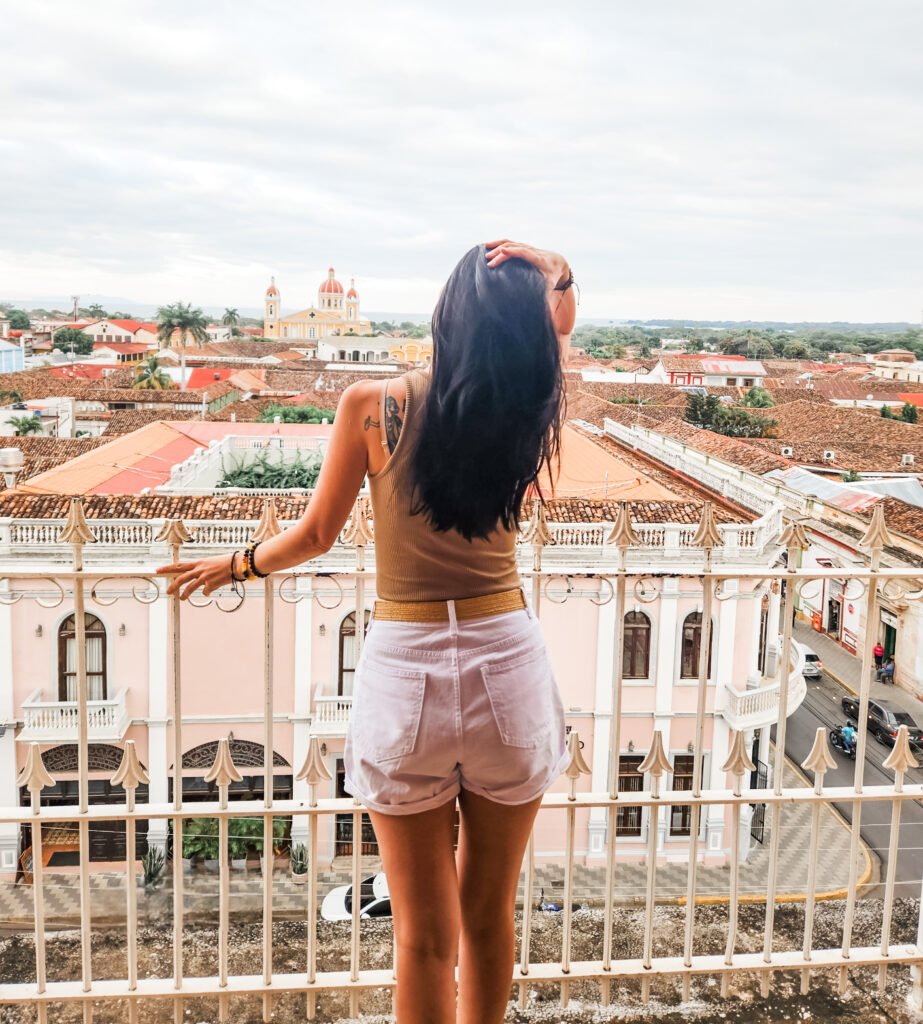Woman on a rooftop terrace overlooking the colonial rooftops of Granada, Nicaragua