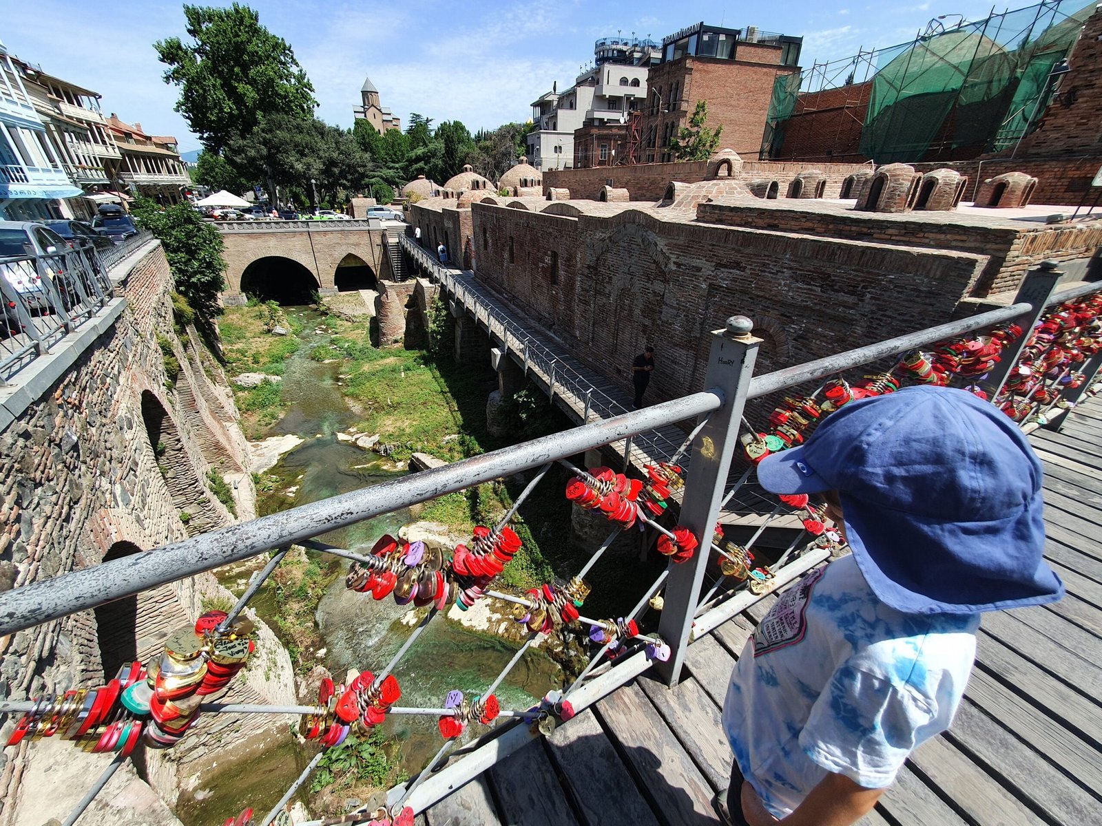 Child looking over a railing at a river gorge in Tbilisi Old Town