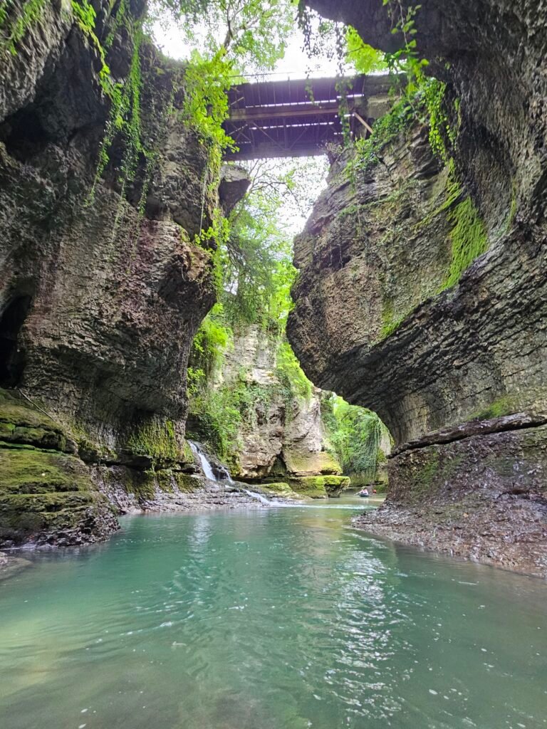 Turquoise river at the bottom of a narrow, moss-covered canyon