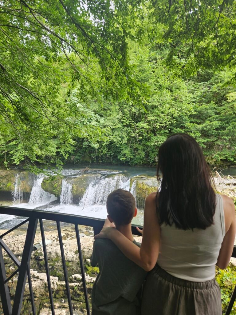 Mother and son looking out at a waterfall from a viewing platform