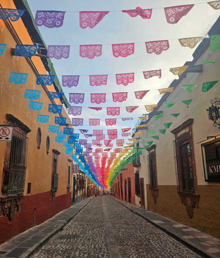 Colourful papel picado bunting over a cobbled street in San Miguel de Allende